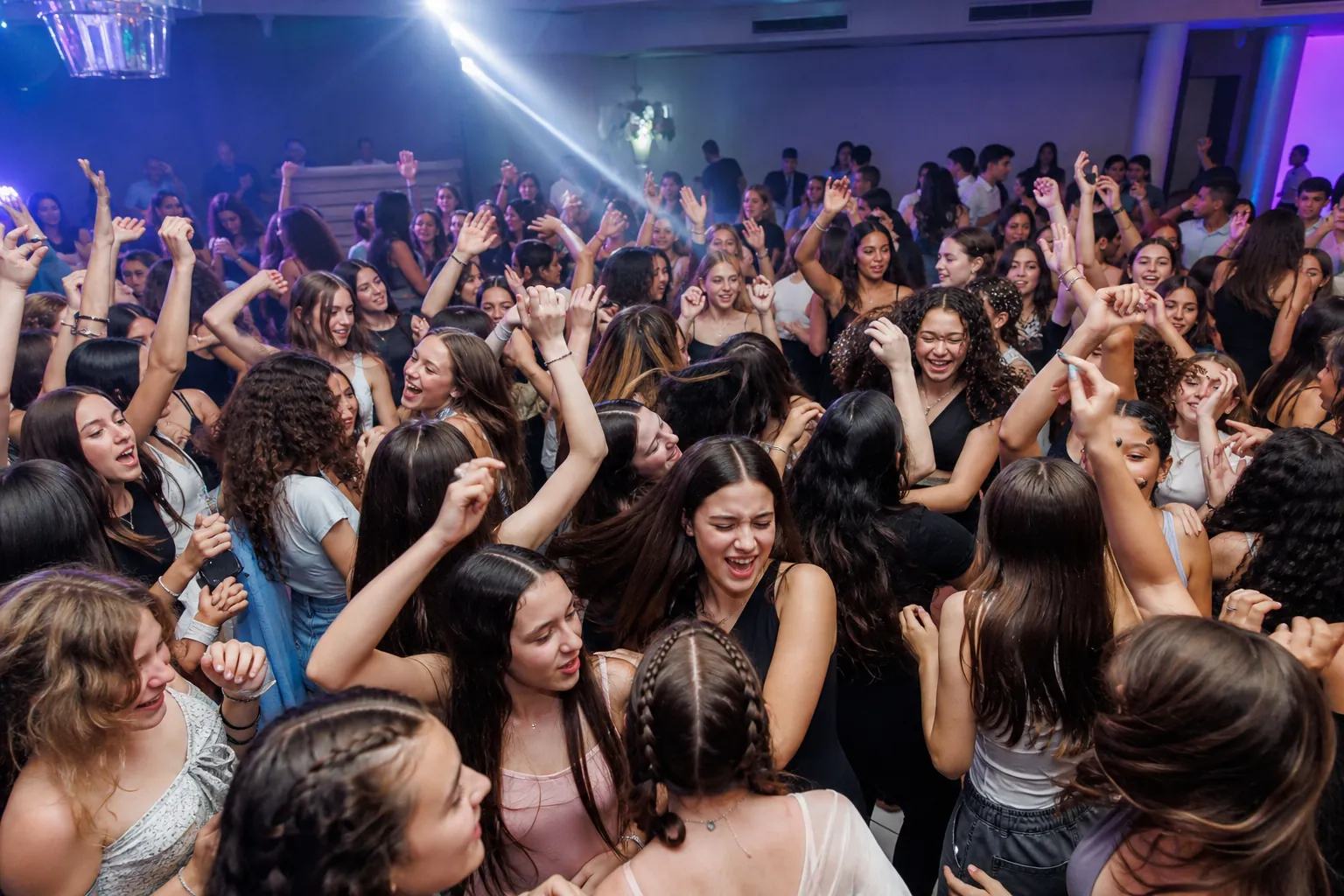 רחבה מלאה של ילדים ובני נוער רוקדים בשיא האירוע, ידיים באוויר וחיוכים אמיתיים